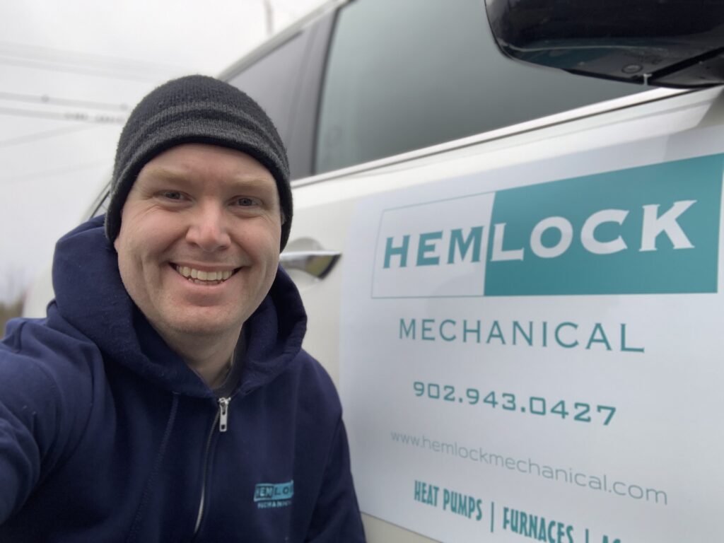 Owner Kyle Young standing beside Truck Signage Hemlock Mechanical